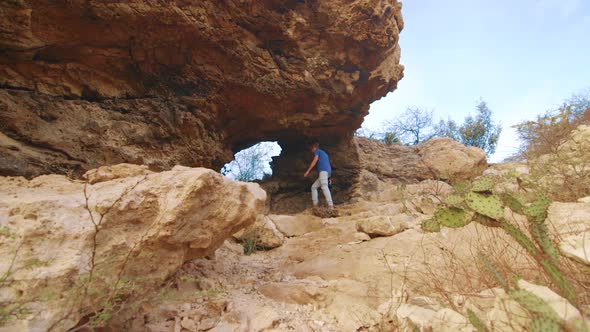 Man Enjoy Walking Into The Natural Bridge In Curacao On Sunny Day - Steady Shot