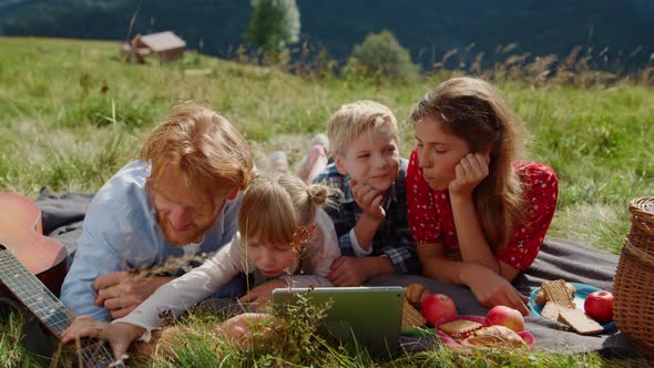 Happy Family Rest Tablet on Green Meadow Sunny Day Close Up