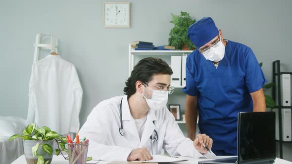 Professional Doctors Wearing Medical Masks Uniforms Discussing Treatment for Patient Showing on