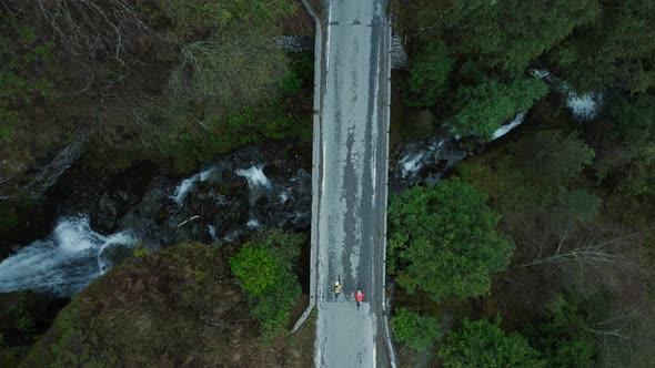 Scenic Aerial Drone Shot of Two Cyclists on Bridge