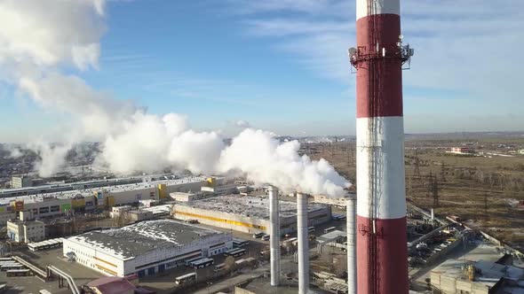 Industrial Zone with a Large Red and White Pipe Thick White Smoke Is Poured From the Factory Pipe