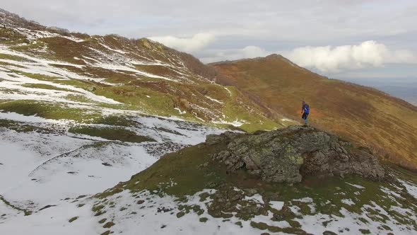 A trail runner runs up a snowy mountain