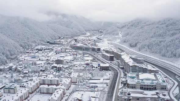 Aerial Reverse View Winter Village Krasnaya Polyana Resort Surrounded By Mountains Covered By Snow