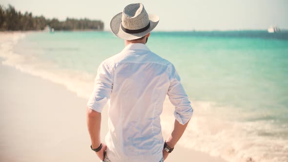 Beautiful Tanned Man In Hat Healthy Skin Sunbathing Enjoy Ocean Vacation. Tropical Sea Resort Hotel.