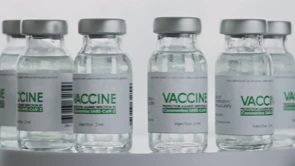 Bottles of vaccine for COVID-19 coronavirus cure are quickly rotated in research lab. Looped