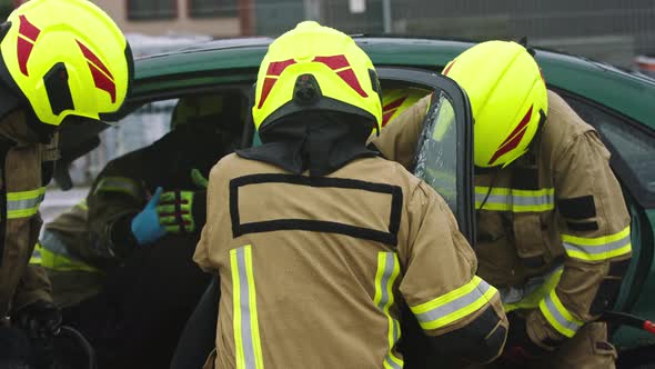 Firefighters Using Jaws of Life To Extricate Trapped Victim From the Car