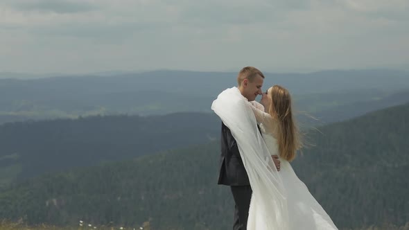 Groom with Bride Having Fun on a Mountain Hills. Wedding Couple Hugging