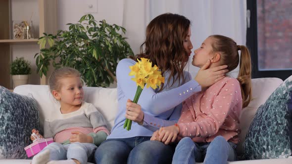 Daughters Giving Flowers and Gift to Happy Mother