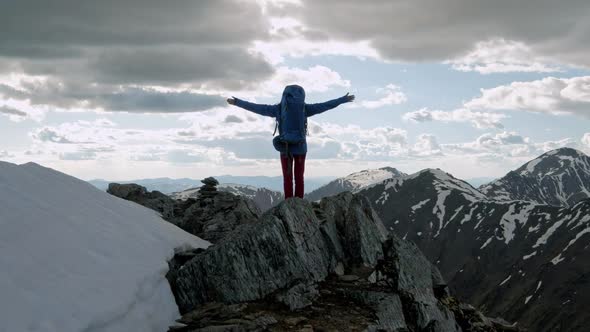 Successful Young Woman Backpacker Open Arms on Mountain Peak