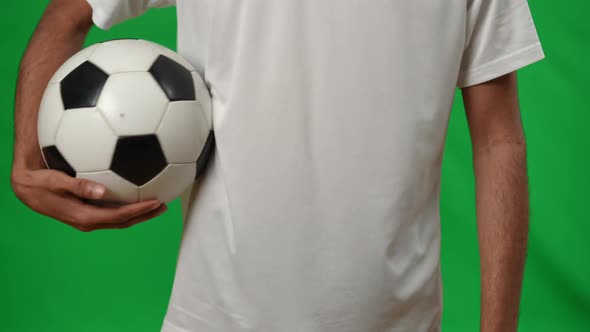 Unrecognizable Middle Eastern Young Man with Soccer Ball on Green Screen Mockup