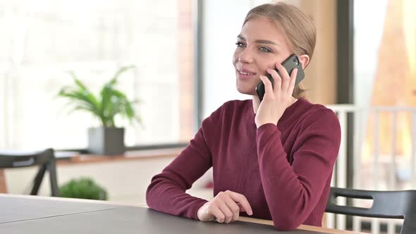 Young Woman Talking on Smartphone in Office