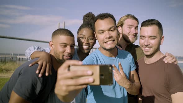 Smiling Friends Gesturing While Taking Selfie with Smartphone