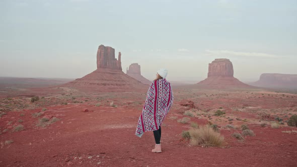 Slow Motion Woman Walking Outdoors Red Canyon with Cliffs Formations in Desert