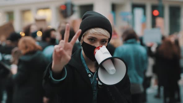 Woman with Face Mask and Megaphone Supporting Anti-racism Protests. Peace Gesture