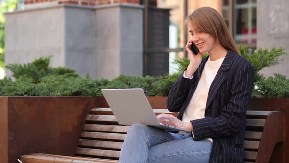 Young Woman Talking on Phone Negotiating in Good Mood