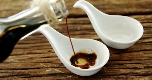 Soy sauce being poured into appetizer spoon