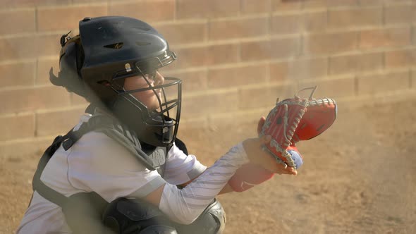 Boy plays catcher in a little league baseball game.