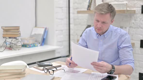 Businessman Studying Documents at Work