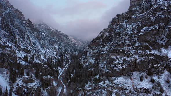 Flying up rugged canyon in winter at dusk following road