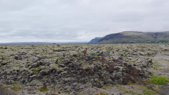 Drone Towards Hiking Couple in Mossy Landscape