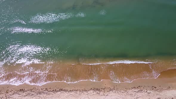 Small sea waves. Soft waves on a sandy beach. Seascape background