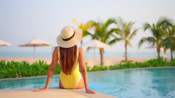 Young asian woman enjoy around outdoor swimming pool for leisure