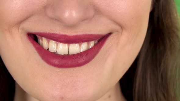 Young Woman with a Red Lips Smiling Revealing Teeth. Close Up