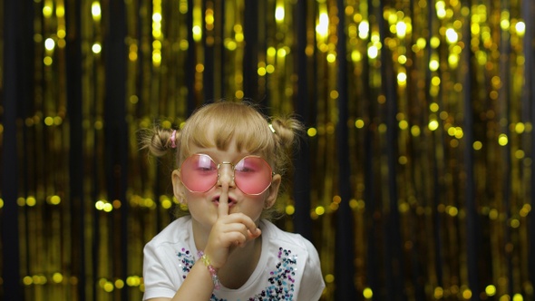 Child Girl Putting Finger on Lips Making Silence Gesture, Asking To Keep Secret. Shh. Be Quite.