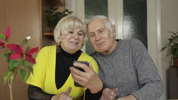 Pretty Mature Senior Couple Grandparents Making Video Call with Phone at Home