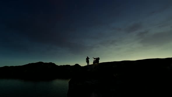 Man Watching the view of the Cliff with his Motorcycle