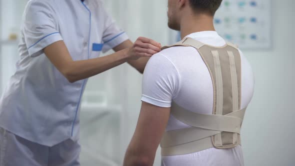 Orthopedist Applying Posture Control Shoulder Brace Male Patient Healthcare