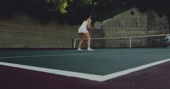 Woman and man playing tennis on a sunny day