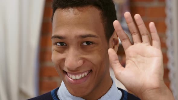 Hello by Young African Man, Loft Background, Waving Hand