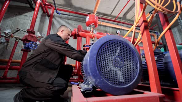 A Water Pumping Station Engineer Repairs the Water Supply Compressor Engine