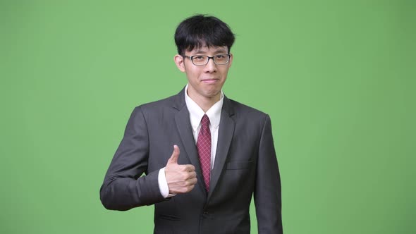 Young Asian Businessman Giving Thumbs Up