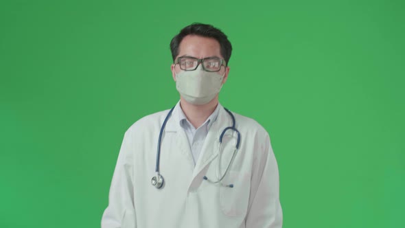 The Front View Of Asian Doctor With Stethoscope Wearing Mask While Walking On Green Screen