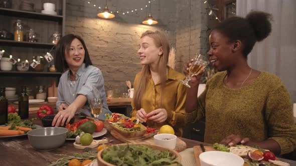 Happy Women Laughing and Cooking in Kitchen Together