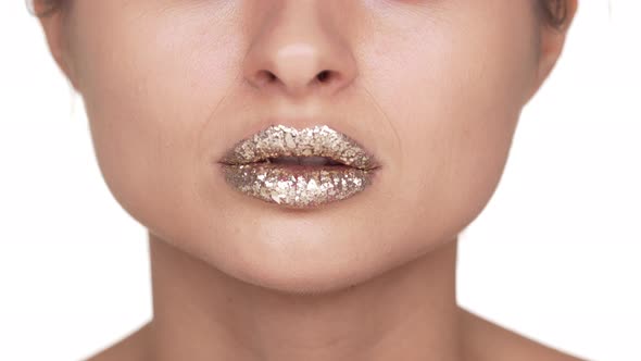 Portrait of Impressive Woman with Dazzling Golden Glitter on Her Lips Doing Kissing Gesture and