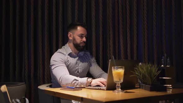 Bearded Businessman Working with Laptop on New Project, Sitting Alone on Cofe Table