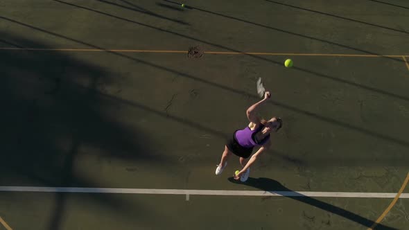 Aerial footage of a female tennis player playing tennis on a tennis court