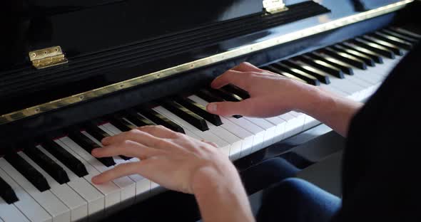 A pianist playing a piece of music on the keyboard of a piano instrument.