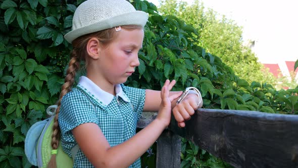 Child schooler using smartwatch outdoor park. Kid talking on vdeo call with parents on smartwatches