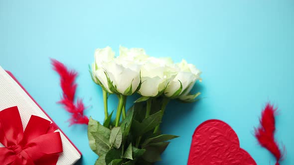 Bouquet of White Roses with Red Bow on Blue Background. Boxed Gift on Side