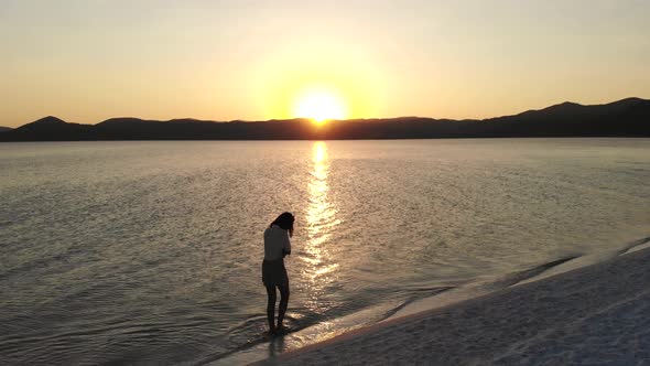 Female Model Walking on the White Sandy Beach of the Clear Tropical Turquoise Sea at Sunset