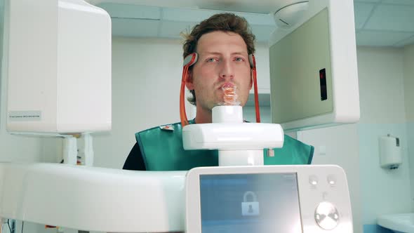 A Man is Having His Teeth Xrayed in the Clinic