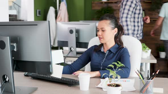 Beautiful Young Female Entrepreneur Typing and Enjoying Her Coffee at the Office