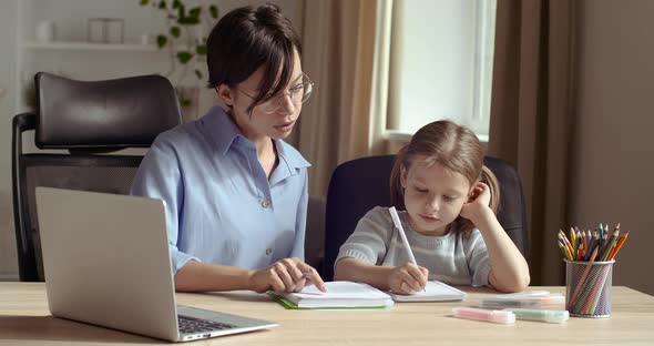 Cute Small Preschool Girl Kid Daughter Learning Writing with Young Mom Tutor. Adult Parent Mother