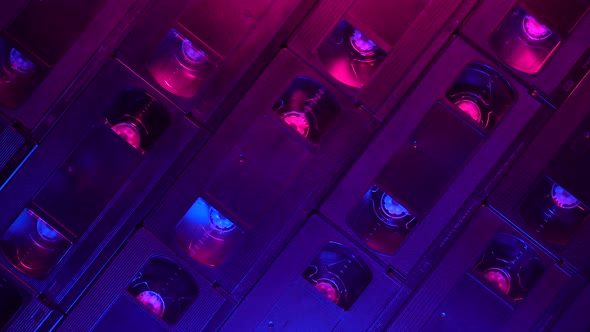 Retro background of VHS cassettes sliding right, blue and purple lighting