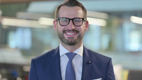 Portrait of Middle Aged Businessman Smiling at Camera