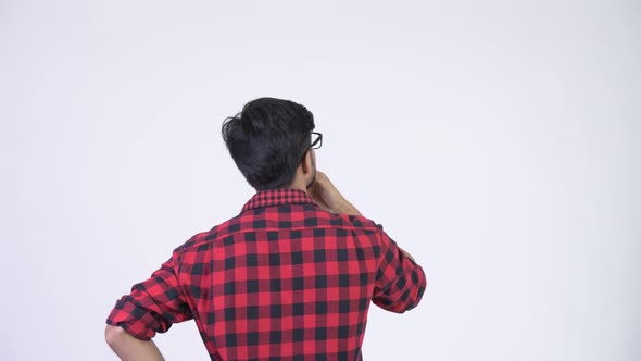 Rear View of Young Handsome Bearded Indian Hipster Man Pointing Finger